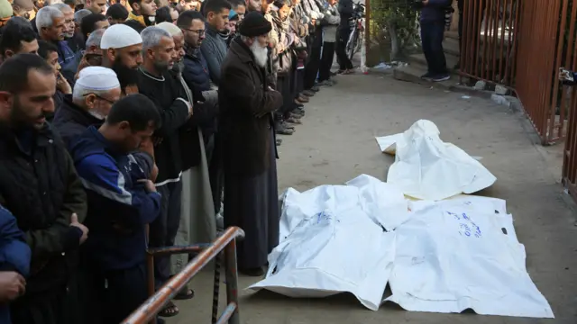 صورة تظهر فلسطينيين يؤدون الصلاة في مستشفى ناصر جنوب قطاع غزة وأمامهم جثامين قتلى سقطوا إثر غارات إسرائيلية.