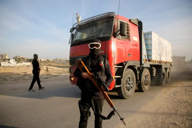 مسلحون فلسطينيون يؤمنون شاحنة مساعدات بعد وقف إطلاق النار بين إسرائيل وحماس، في رفح