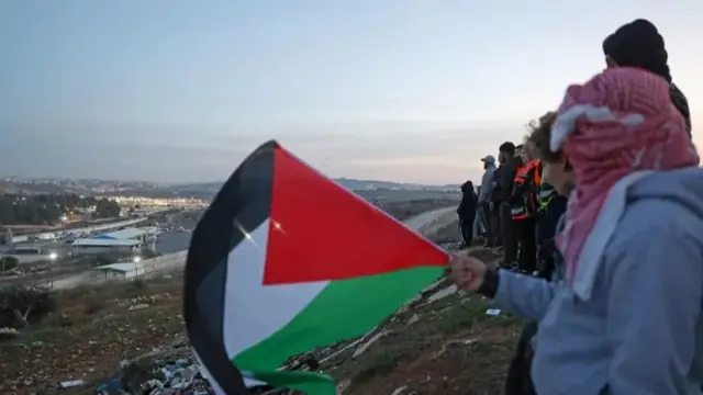 فسلطینی‌های کرانه‌ باختری در تپه‌ای مشرف به زندان عوفر ایستاده‌اند