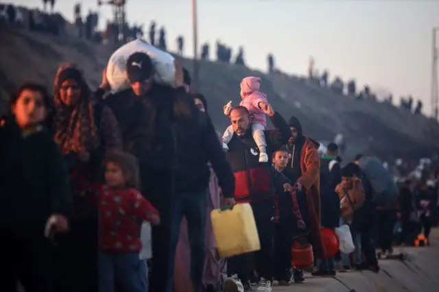 فلسطينيون يحملون أمتعتهم البسيطة أثناء العودة إلى مناطقهم