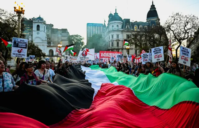 مؤيدون للفلسطينيين يحملون علماً فلسطينياً ضخماً خلال مظاهرة تضامناً مع أسطول الصمود العالمي وغزة في بوينس آيرس في الأرجنتين