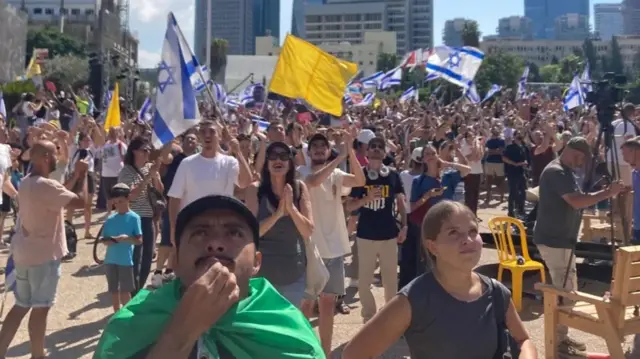 حشود تنظر إلى السماء في تل أبيب، بينما تحلق مروحيات تقل رهائن أفرج عنهم