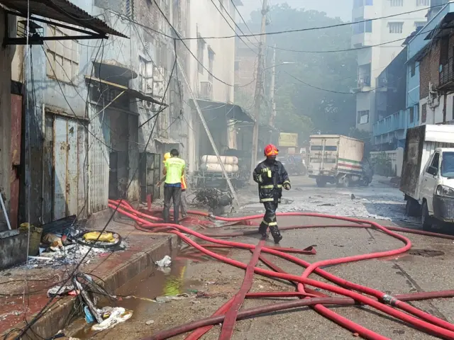 একটি রাস্তায় পানির পাইপ নিয়ে কাজ করছেন ফায়ার সার্ভিসের দুই জনসহ মোট তিন কর্মী