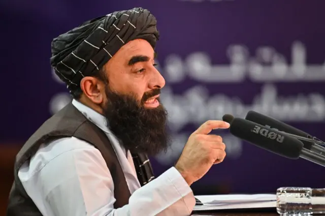کالی پگڑی پنے ہوئے افغانستان کی حکومت کے ترجمان ذبیح اللہ مجاہد ہریس کانفرنس سے خطاب کر رہے ہیں۔