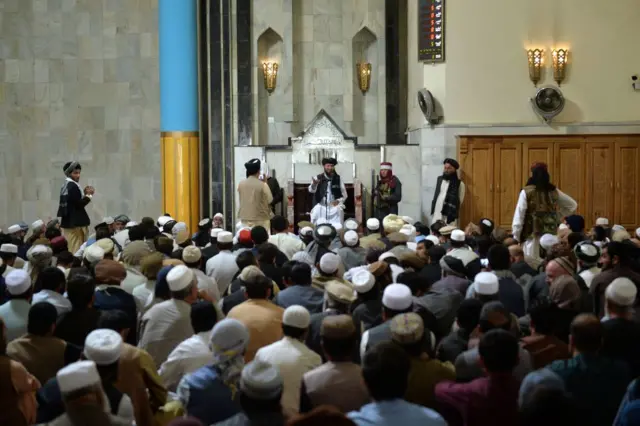 د پل خشتي جومات پر ممبر ملا ناست دی او وعظ کوي. لاندې ورته سلګونه مقتدیان غوږ دي.