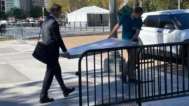 Двоє чоловіків несуть велику мапу