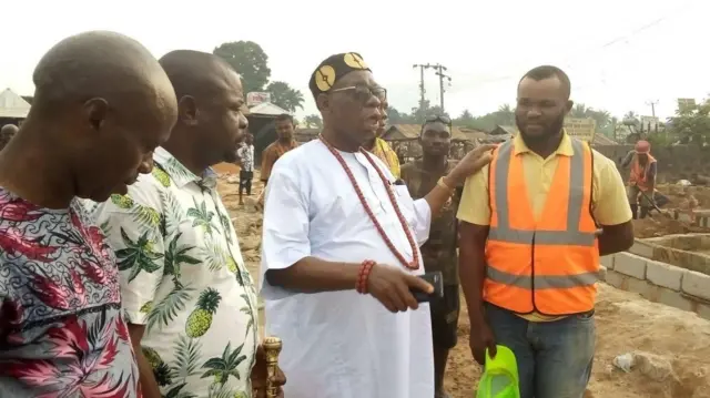 Eze Asor yi uwe ọcha kpuru okpu ojii, ụmụnwoke atọ nọ ya n'akụkụ abụọ