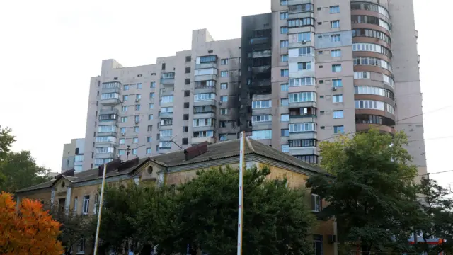 У многоэтажного дома, облицованного кирпичом, несколько верхних этажей со следами пожара
