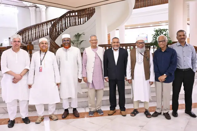 প্রধান উপদেষ্টার সঙ্গে দাঁড়িয়ে আছেন জামায়াতের চার জন প্রতিনিধি এবং অন্তর্বর্তী সরকারের তিন জন উপদেষ্টা