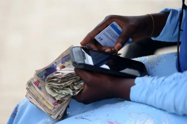 Wani mutum riƙe da takardun naira