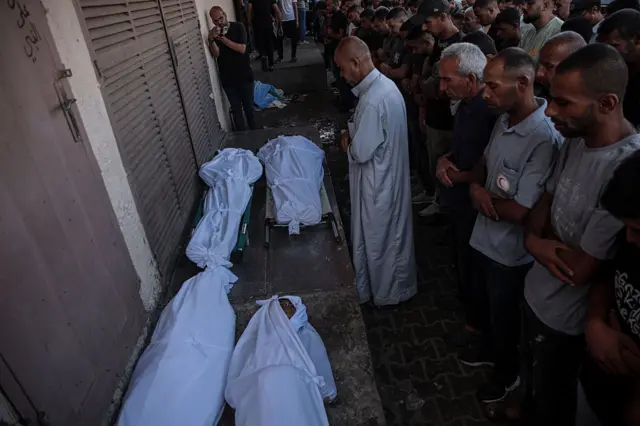 صورة بتاريخ 4 أكتوبر/تشرين الأول 2025، من داخل مستشفى شهداء الأقصى لفلسطينيين يؤدون صلاة الجنازة على بعض من قتلى القصف الإسرائيلي.