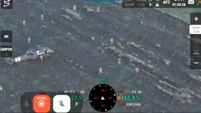Кадр из зернистого видео с дрона, можно различить вертолет и фигуры солдат