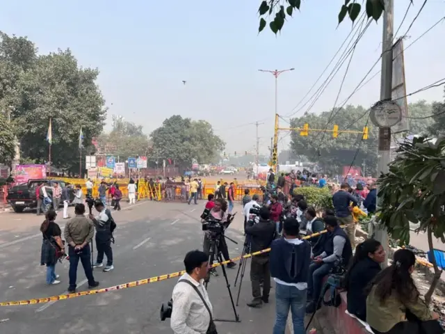দিল্লিওেত বিস্ফোরণের ঘটনাস্থল ঘিরে রাখা হয়েছে পুলিশের ক্রাইম সিন ফিতা দিয়ে, এর মধ্যে বিভিন্ন জায়গায় ক্যামেরাসহ দাঁড়িয়ে আছেন সাংবাদিকরা