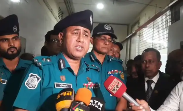 রাজশাহী মেট্রোপলিটন পুলিশ কমিশনার আবু সুফিয়ান সংবাদ মাধ্যমের সঙ্গে কথা বলছেন, তার পেছনে কয়েকজন পুলিশ সদস্য ও সাদা পোশাকের কয়েকজন ব্যক্তি