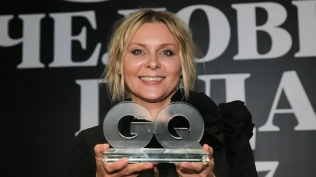 Улыбающаяся Яна Троянова с премией GQ в руках.