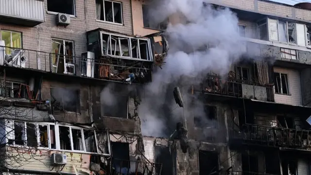 Жилой дом с балконами, примерно с третьего этажа идет дым.