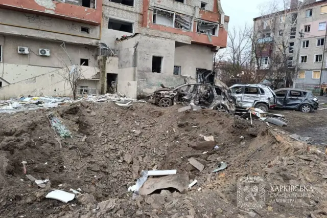 Поврежденные машины перед многоэтажным домом.