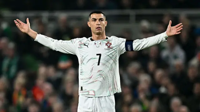 كريستيانو رونالدو بلباسه الرياضي الأبيض في ملعب لكرة القدم