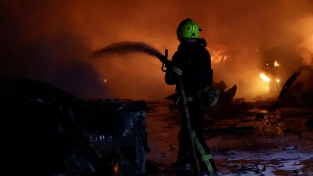 Пожарный заливает пламя