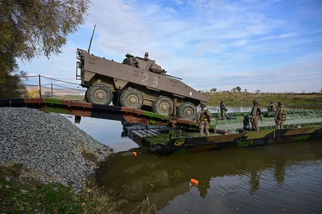 Французские военные инженеры грузят бронемашину на плавучий моторизованный мост на учениях в Румынии