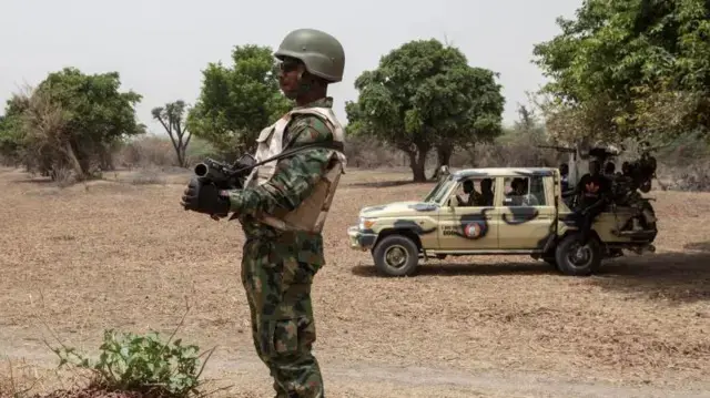 wani soja tsare a gefen motar sojoji cikin wani daji