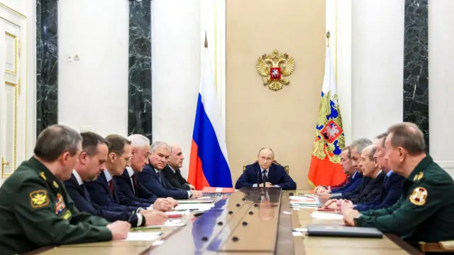 Члены Совета безопасности РФ сидят за длинным столом по обе стороны от Путина