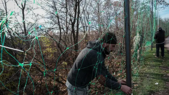 Мужчины натягивают противодроновую сетку