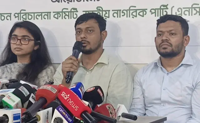 এনসিপির মুখ্য সংগঠক নাসীরুদ্দীন পাটওয়ারী কথা বলছেন, দুই পাশে দলের আরো দুই নেতা