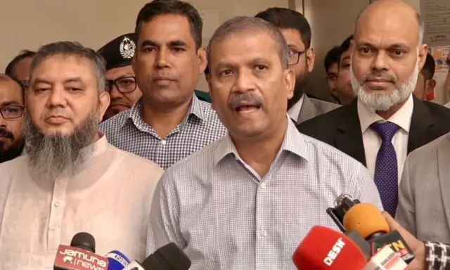 আসিফ নজরুল ক্যামেরার সামনে কথা বলছেন, তার দুই পাশে দাঁড়িয়ে আছেন কয়েকজন