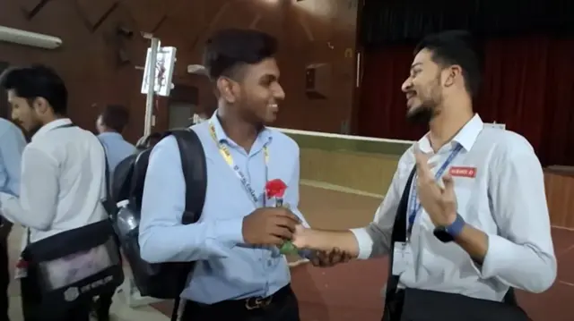 আইডিয়াল ও ঢাকা উভয় কলেজের দুই জন শিক্ষার্থী একে অপরকে ফুল দিচ্ছেন