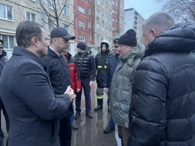 Бусаргин с группой мужчин во дворе дома