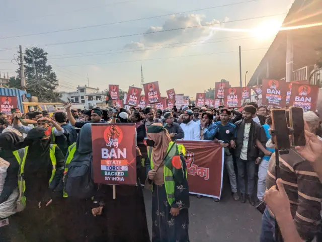 ব্যানার ও প্ল্যাকার্ড হাতে বিক্ষোভকারীদের অবস্থান