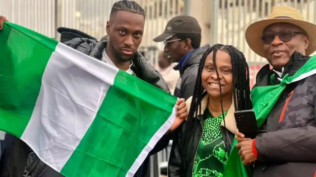 Man hold Nigeria flag, woman dey im side
