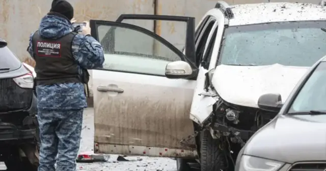 Полицейский у взорванногог автомобиля