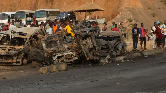 People stand at the scene of an accident after a truck kills six and destroys several vehicles in Karu, Abuja