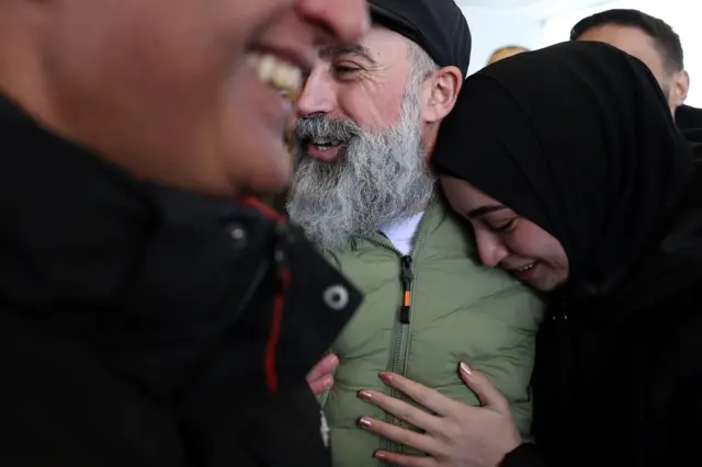 أسير فلسطيني سابق، أُطلق سراحه في إطار صفقة تبادل الأسرى السادسة، يعانق أحد أقاربه لدى وصوله إلى مدينة رام الله بالضفة الغربية المحتلة في 15 فبراير/شباط 2025.