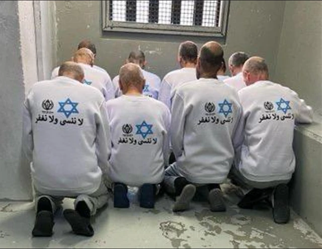 سجناء فلسطينيون يرتدون قمصاناً مكتوب عليها "لا ننسى ولا نغفر"