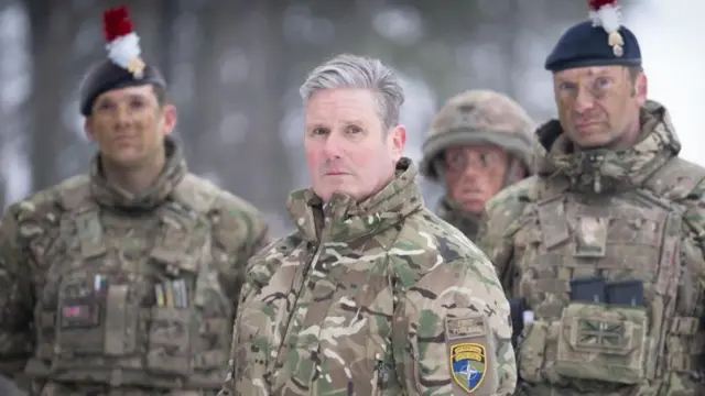 Кир Стармер в военной форме в окружении нескольких солдат.