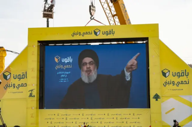 صورة أرشيفية لحسن نصر الله، الأمين العام السابق لحزب الله، أثناء خطابه، يظهر في شاشة كبيرة