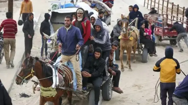 صورة لنازحين فلسطينيين في طريق عودتهم إلى منازلهم في غزة.