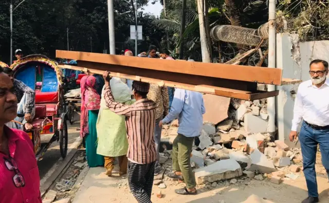 ধানমন্ডি ৩২ নম্বর থেকে অবকাঠামো খুলে নিয়ে যাচ্ছেন এক ব্যক্তি।