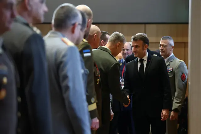 Эммануэль Макрон по очереди здоровается за руку с людьми в военных формах разных стран