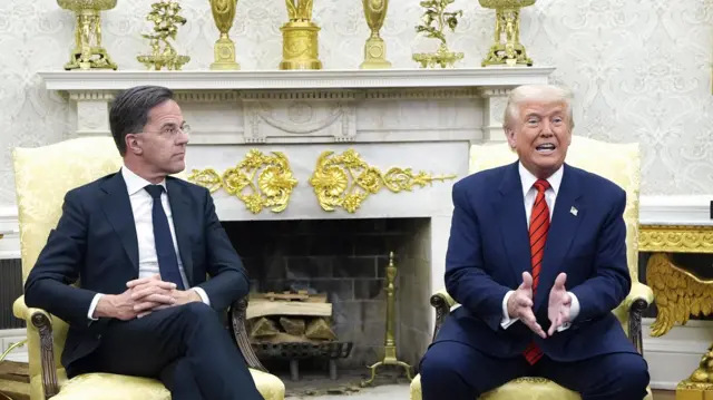 Трамп говорит жестикулируя у камина в Овальном кабинете, рядом генеральный секретарь НАТО Марк Рютте смотрит на него, сидя в золоченом кресле