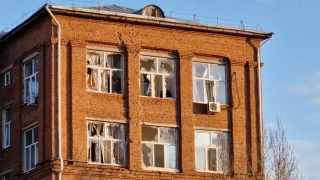 Здание из красного кирпича, в котором выбиты несколько окон