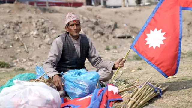 तीनकुनेमा राष्ट्रिय झण्डा लिएका व्यक्ति