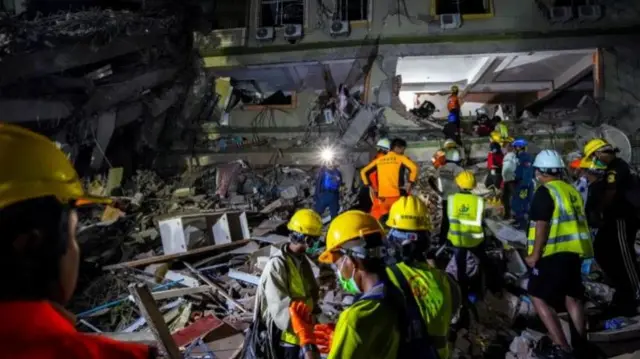 म्यांमार के मांडले में तलाशी अभियान में जुटे बचाव दल के लोग