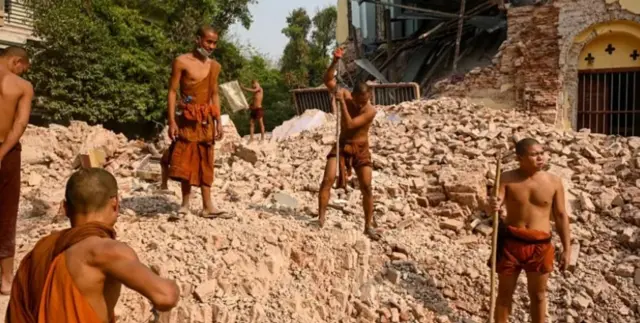 Ndị Buddhist mọnk na-ekpocha ihe n’ebe obibi ndị mọnk dị na Thahtay Kyaung mebiri emebi na Mandalay