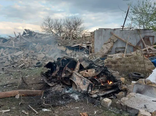 Разрушенные дома и автомобиль