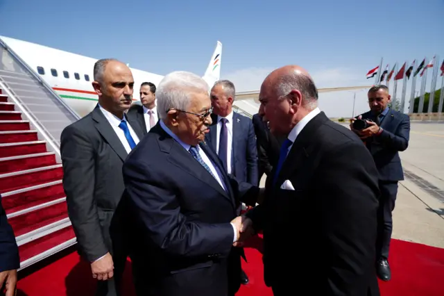 وزير الخارجية العراقي فؤاد حسين يرحب بالرئيس الفلسطيني محمود عباس لدى وصوله إلى مطار بغداد الدولي قبل القمة العربية