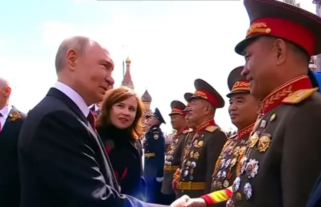 Путин пожимает руки северокорейским военным